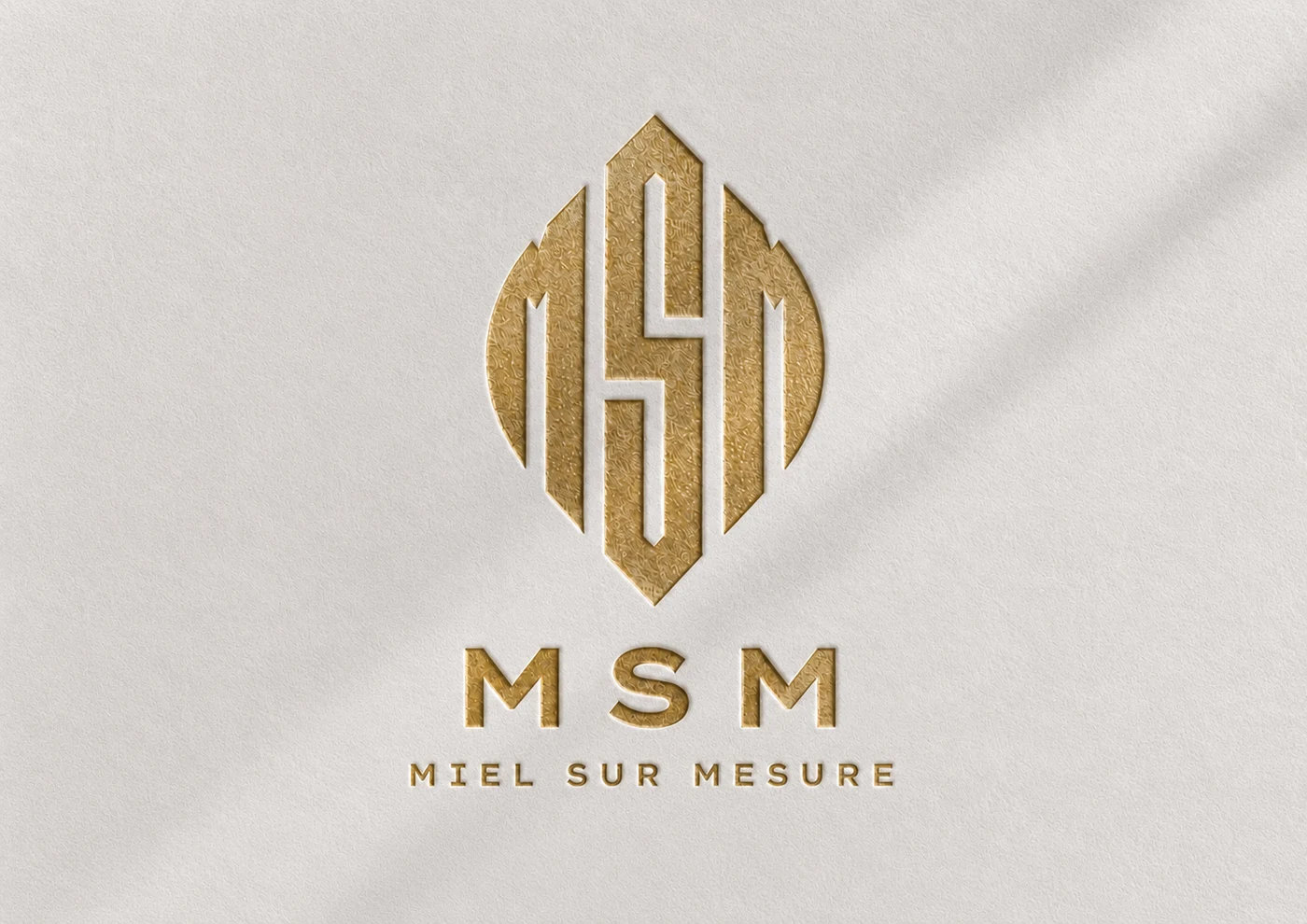 Logo MSM en letterpress doré sur papier texturé